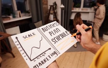 Person holding a notebook with planning details and graph for business strategy indoors.